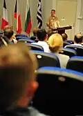 U.S. Navy Capt. Bradley D. Martin spricht vor einer Großübung zum Publikum bei der NMIOTC.