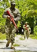 Soldat der U.S. Navy mit einer „Red Gun“ (Nachbildung einer M16)