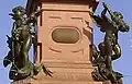 Mendebrunnen, Die Putten am Fuße des Obelisken