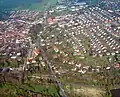 Die Innenstadt von Uslar und die Wohnsiedlung Eichhagen (rechts im Bild). Im unteren Bereich überquert der von Allershausen kommende Fußweg auf der ehemaligen Bahnstrecke die in westlicher Richtung aus Uslar hinausführende Alleestraße.
