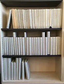 Ein Foto der etwa 70 erschienenen Vestigia-Bände, in einem Bücherregal, auf drei Regalbretter verteilt