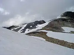 Zerklüftete Landschaft von schneebedecktem Geröll an einem wolkigen Tag