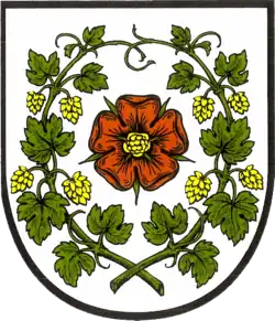 Buckow (Märk. Schweiz) zeigt eine rote Rose mit umrankenden grünen Hopfenzweigen