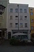 Fassade eines Hauses mit verdecktem Grabendach, erkennbar ist der Regenwasser-Auslass in der Attika (Wasserburg am Inn)