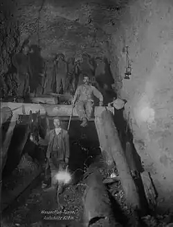 Nach dem Bau des Sohle­stollens und dem Aufschlitzen des Firstes weiten nun die Arbeiter den Tunnel auf das endgültige Profil aus