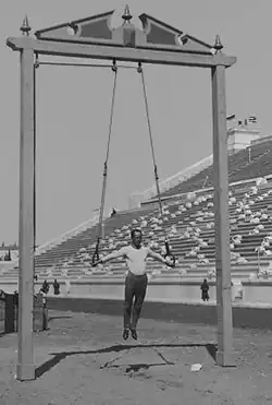 Der ehemalige deutsche Turner und Olympiasieger Hermann Weingärtner zeigt bei den Olympischen Spielen 1896 an einem im Freien stehenden Ringegerüst einen Kreuzhang.