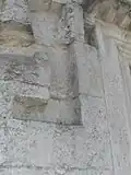Links oben neben der Eingangstür des Obergeschosses in die Außenwand eingearbeitete Einbuchtungen für die Aufnahme architektonischer Verkleidungselemente.
