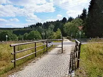 Barriere aus Holz und Kopfsteinpflaster vor Pleystein
