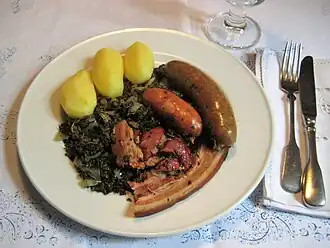 Braunkohl, Bremer Pinkel, Kohlwurst (Schinkenkochwurst), Kassler, gestreifter Bauchspeck und Salzkartoffeln.
