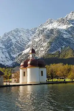 St. Bartholomä (603 m) und Watzmannfrau (2307m, ganz rechts), Watzmann-Südspitze (2713 m, hinten links mit der gebänderten Ostwand und scheinbar etwas niedriger), dazwischen die Watzmannkinder (etwas rechts über der Kirche)