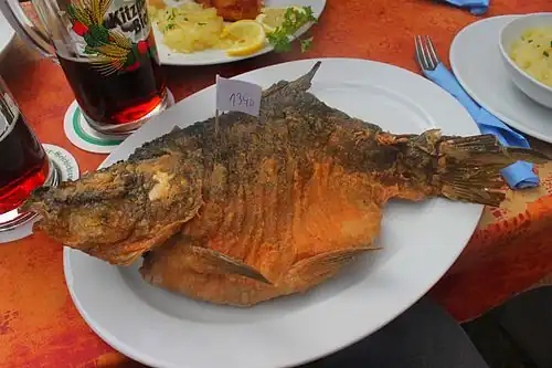 Im Bierteig ausgebackener Spiegelkarpfen mit Preisschild, Preis nach Gewicht