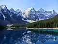 Der Moraine Lake im „Tal der zehn Bergspitzen“ mit Tonsa Mountain (3057 m), Mount Perren (3051 m), Mount Allen (3310 m), Mount Tuzo (3246 m), Deltaform Mountain (3424 m) und Neptuak Mountain (3233 m; von links nach rechts)