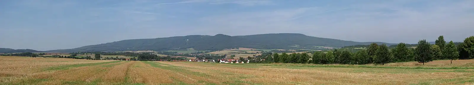 Meißnerblick südlich von Abterode: Abterode  mit Kirche liegt vorne in der Bildmitte. Der weiße Punkt schräg links über dem Dorf ist der Aussichtspunkt Schwalbenthal. Die Bergspitze rechts davon ist die Kalbe (ebenfalls ein schöner Aussichtspunkt) . Rechts neben der Kalbe läuft der Meißner in der Kasseler Kuppe aus. Die mit 754 m höchste Erhebung des Meißner ist touristisch uninteressant.