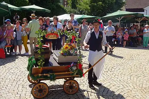 Auf dem Leiterwagen werden Bier und Bierkrüge transportiert.