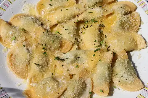 Schlutzkrapfen mit Spinat-Ricotta Füllung mit flüssiger Butter übergossen und mit Parmesanspänen bestreut.